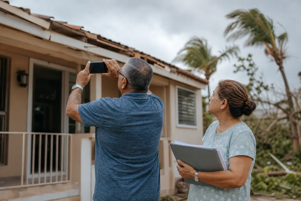 Pareja mayor fotografía el daño del techo de su casa después de una tormenta.